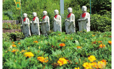 花に囲まれた六地蔵がお参りを出迎えます。